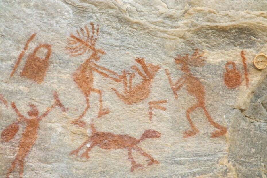 Ocre cave painting depicting human figures and animals
